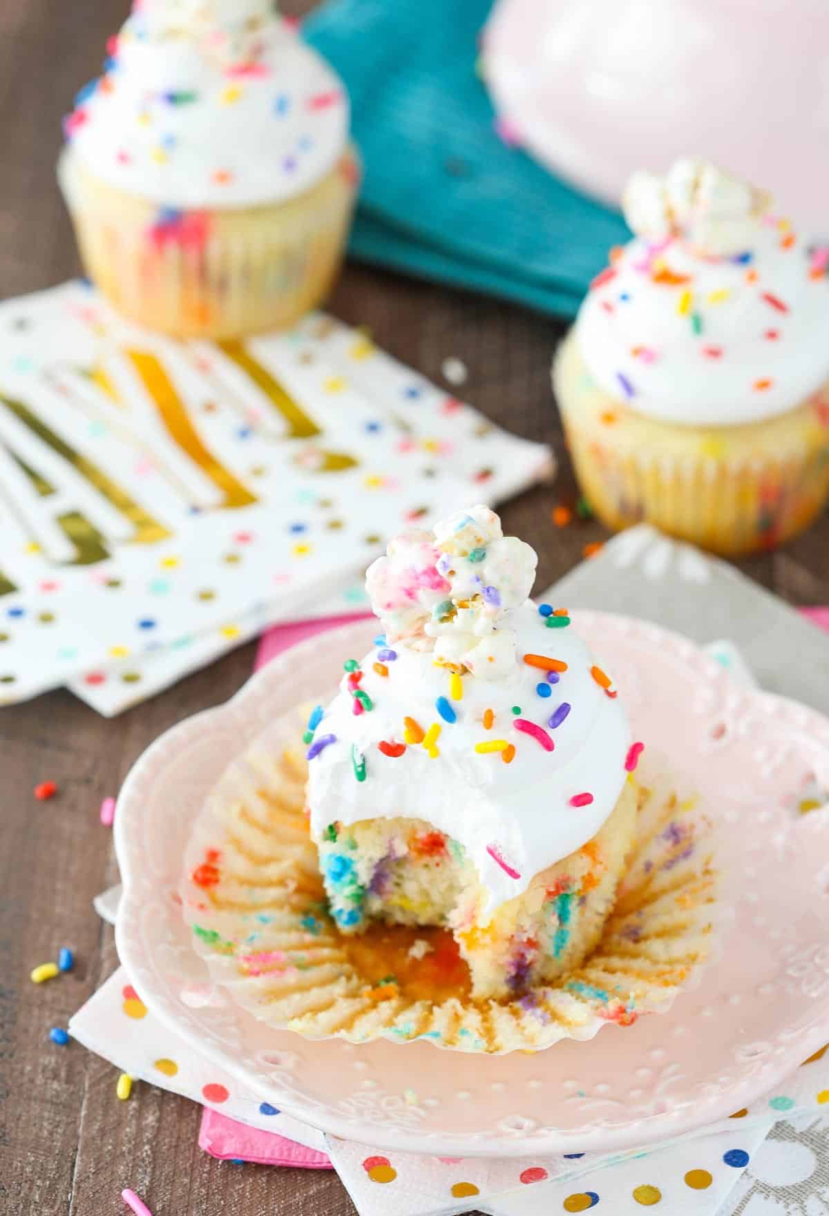A funfetti popcorn marshmallow treat cupcake with a bite taken out of it.