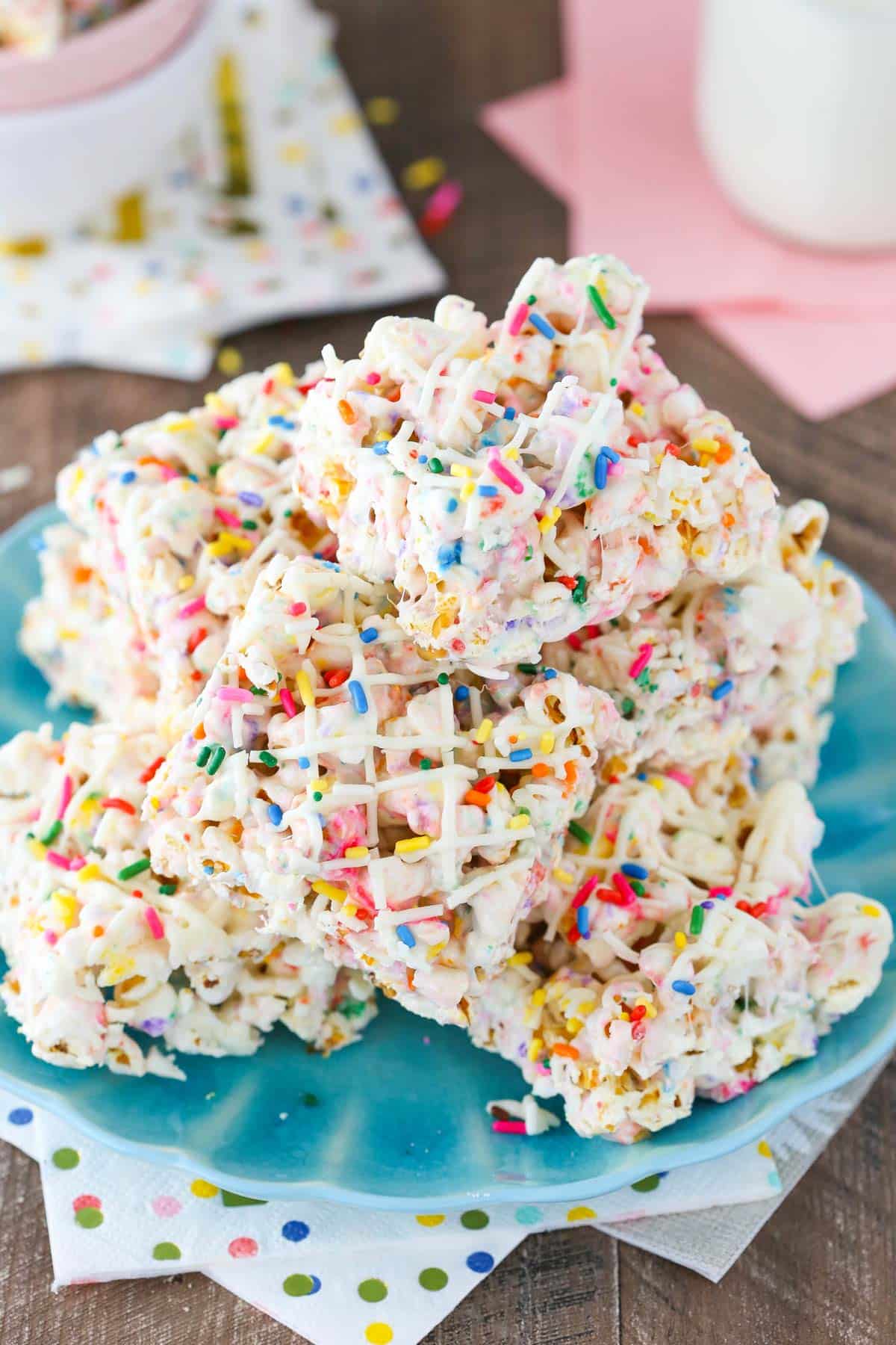 A pile of funfetti marshmallow popcorn treats on a light blue plate.