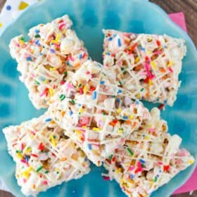 Top view of funfetti marshmallow popcorn treats on top of a light blue plate.