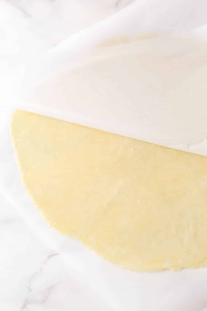 Peeling a sheet of parchment off pie dough that's been rolled out.