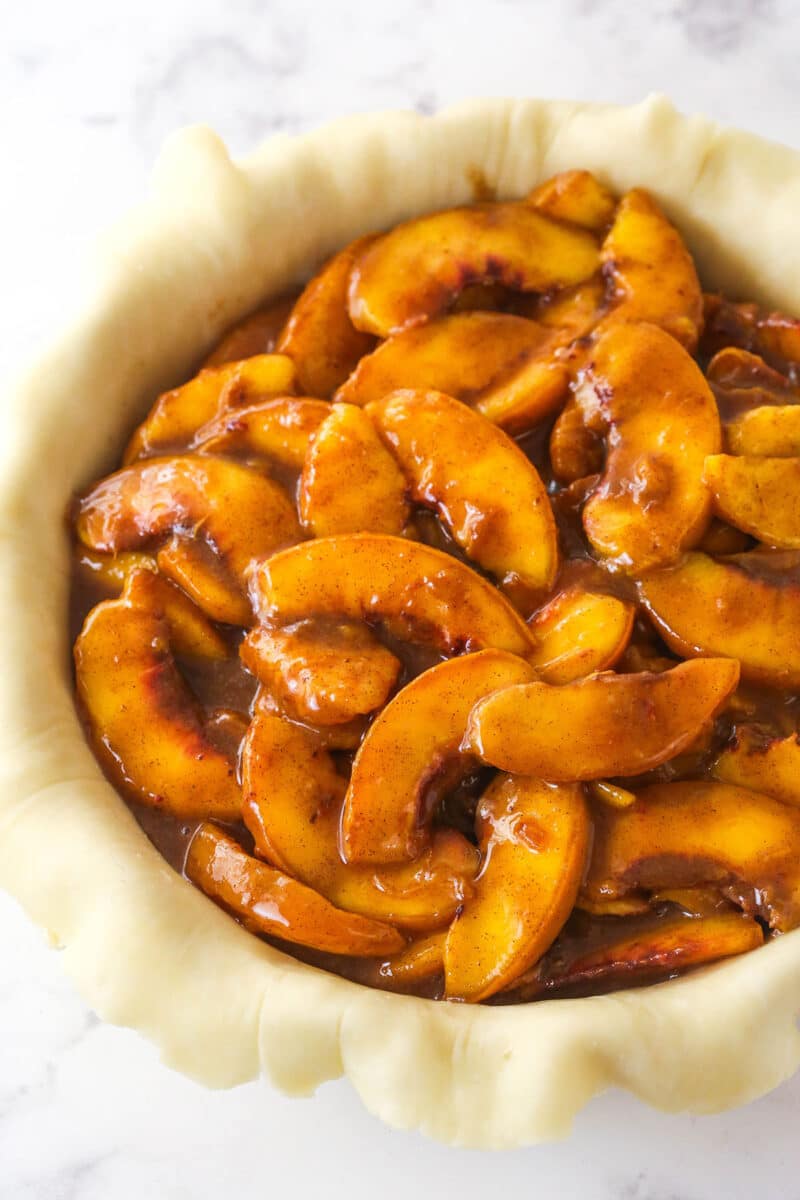 Filling pie dough with peach filling.
