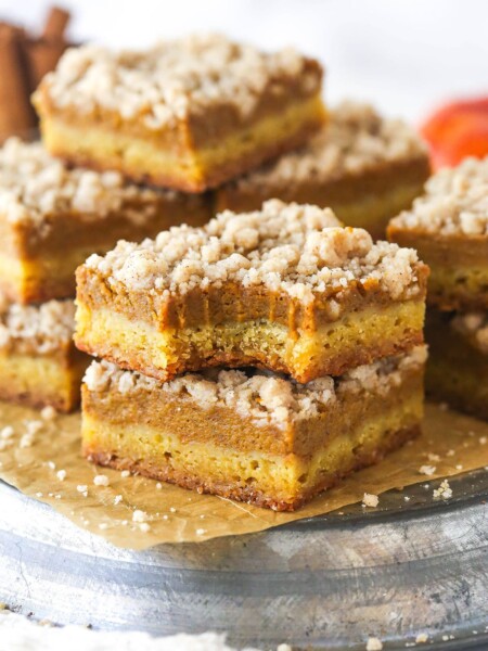 A stack of two pumpkin pie blondie bars. One has a bite taken out of it.