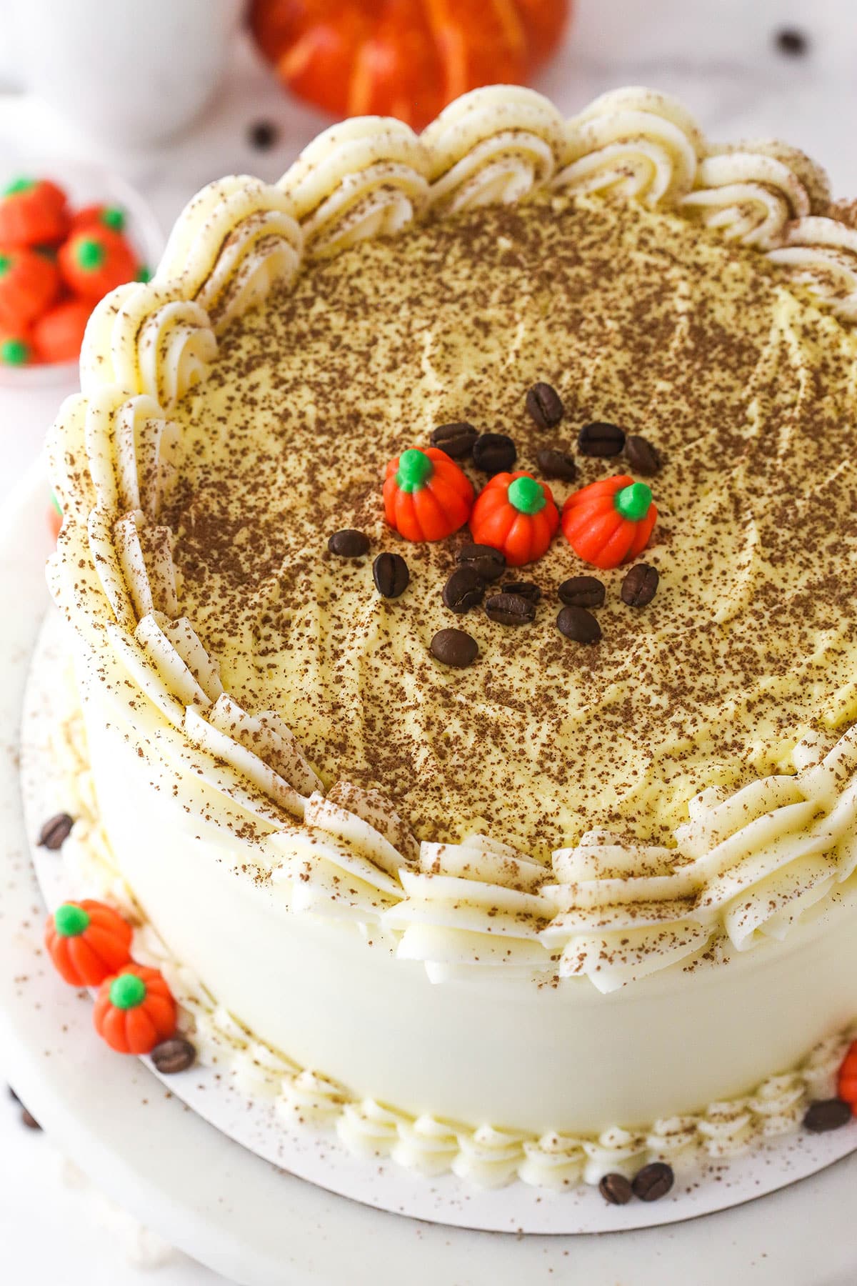 Overhead image of pumpkin tiramisu layer cake on a cake stand.