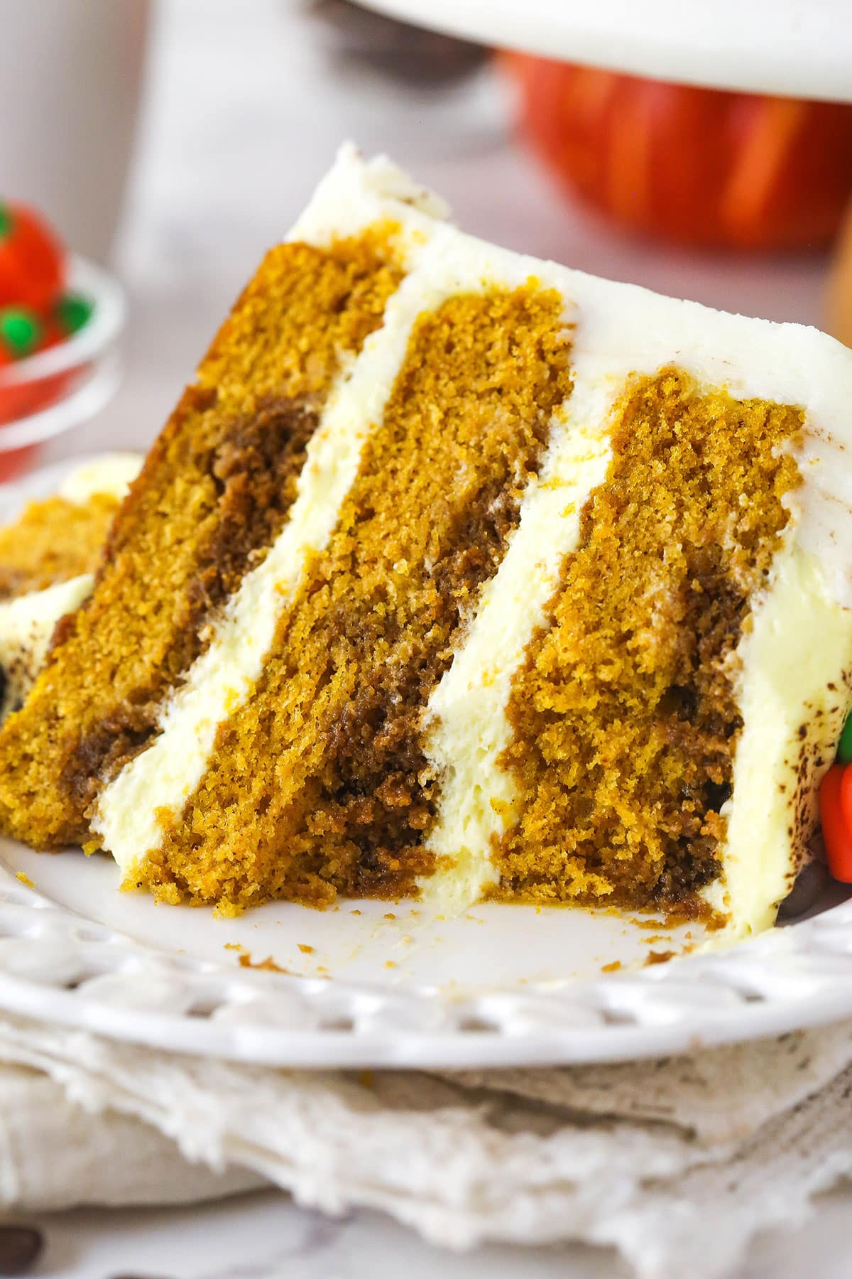 A slice of pumpkin tiramisu layer cake on a plate with a bite taken out of it.