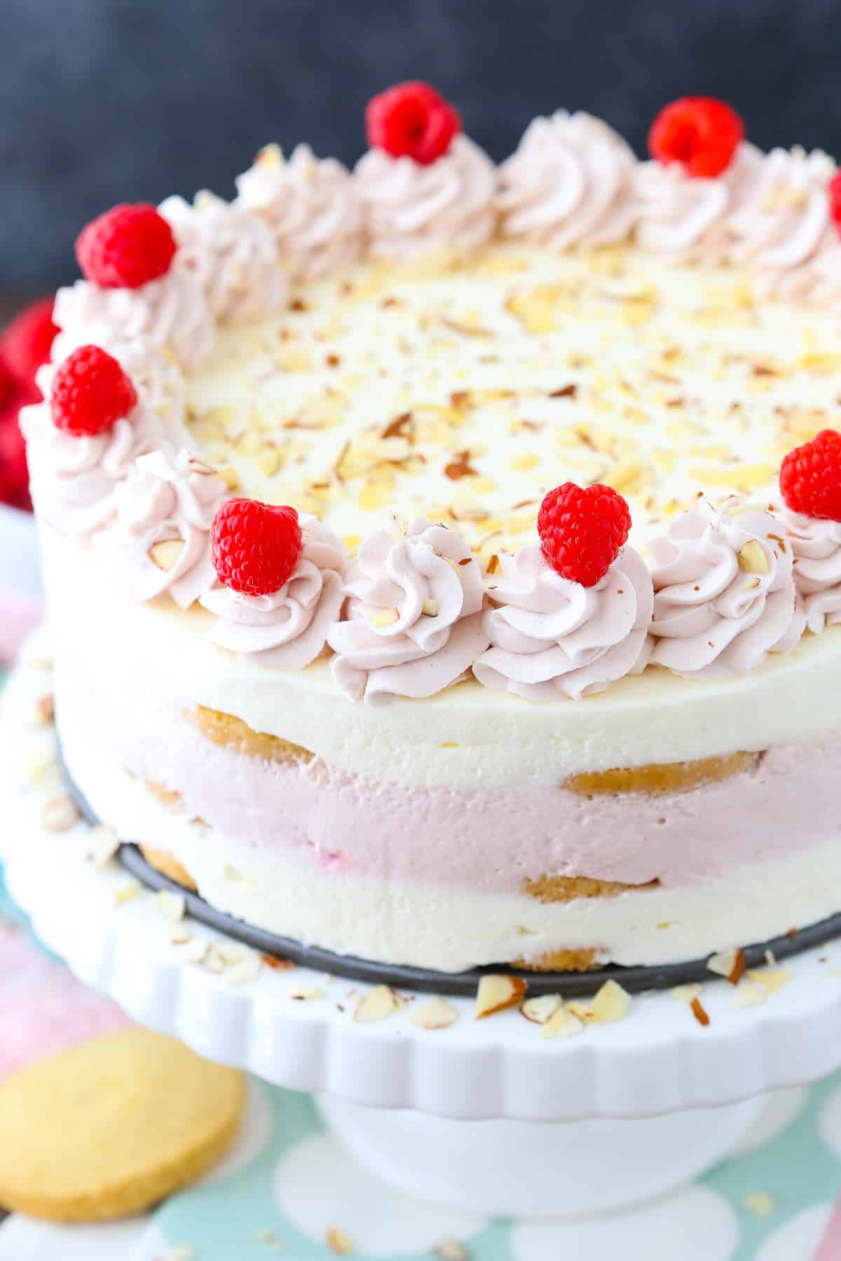 Side view of a raspberry almond shortbread icebox cake on a white cake stand.