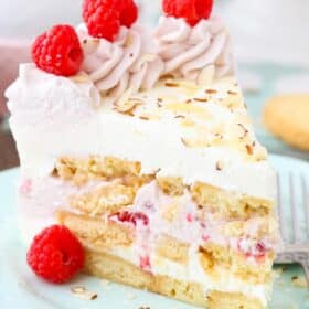 Close up of a slice of raspberry almond shortbread icebox cake on a light blue plate.