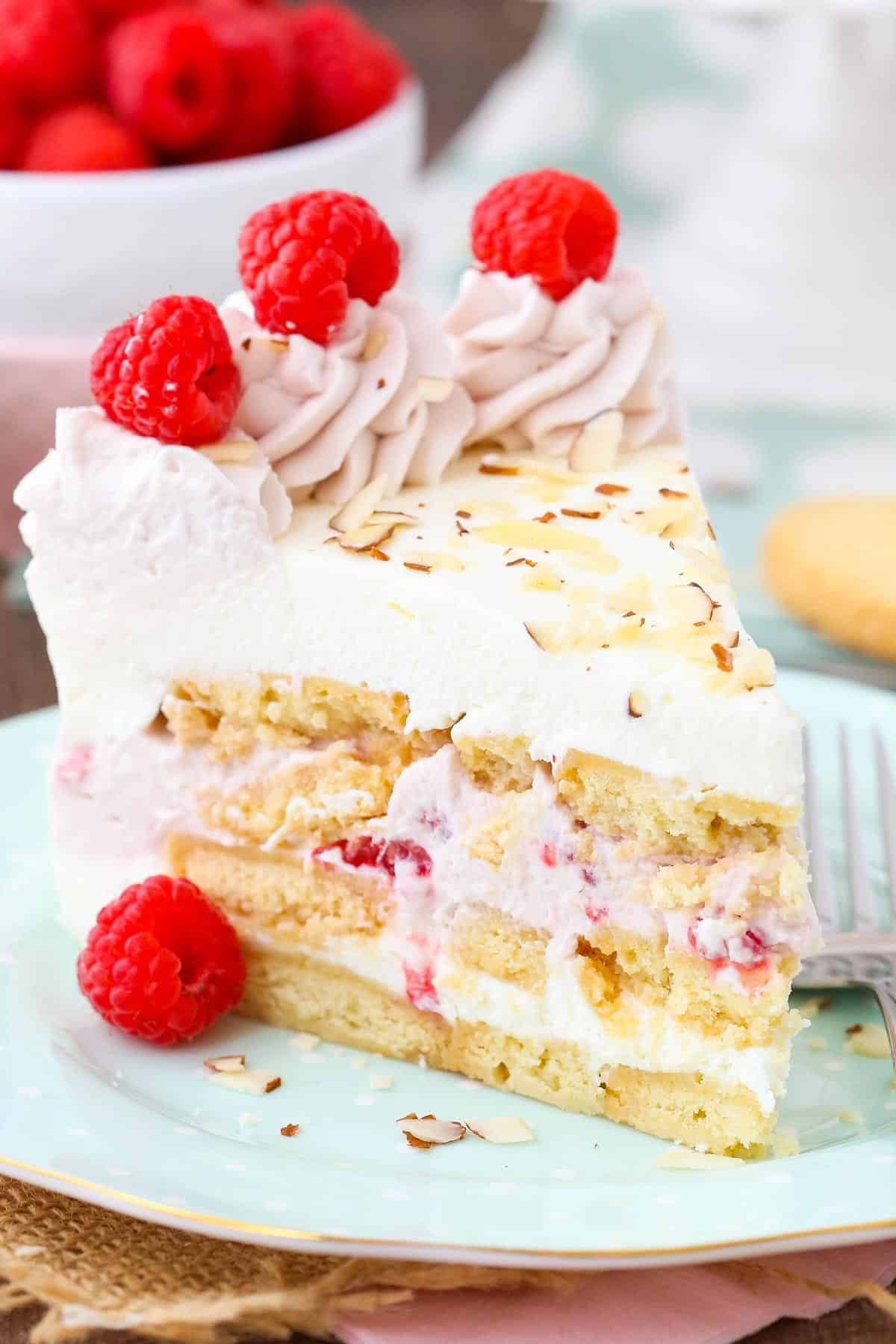 Close up of a slice of raspberry almond shortbread icebox cake on a light blue plate.