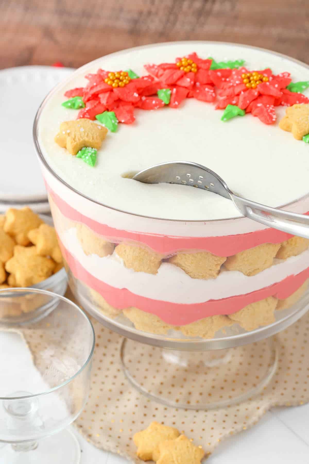 A red velvet shortbread trifle with a serving spoon preparing to take a serving.
