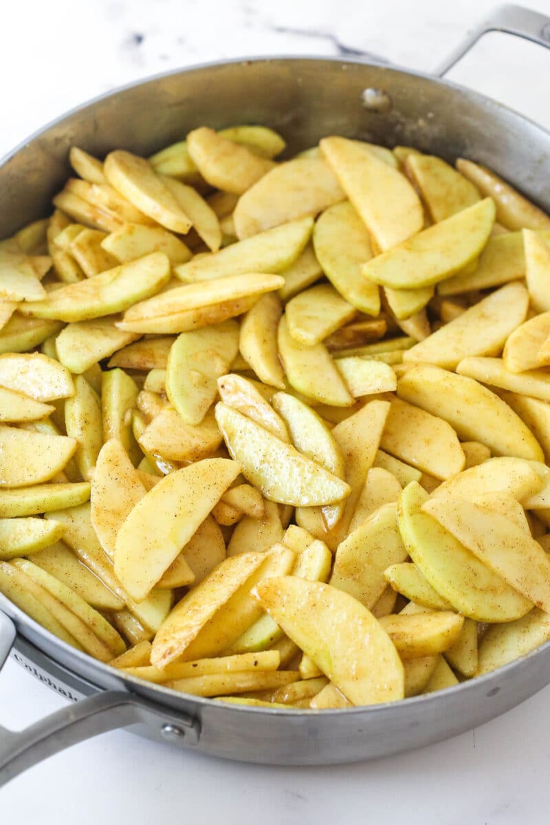 Cooking apple slices in a skillet with sugar, spices, and a smidge of salt.