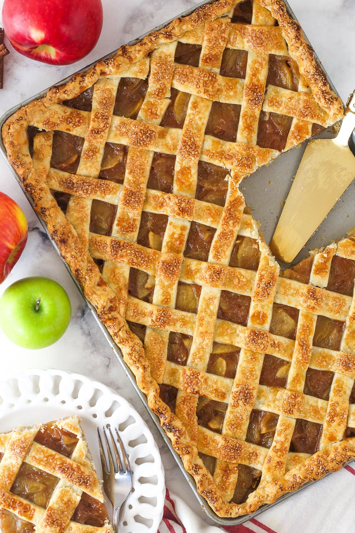 Overhead image of apple slab pie with a slice taken out of it.