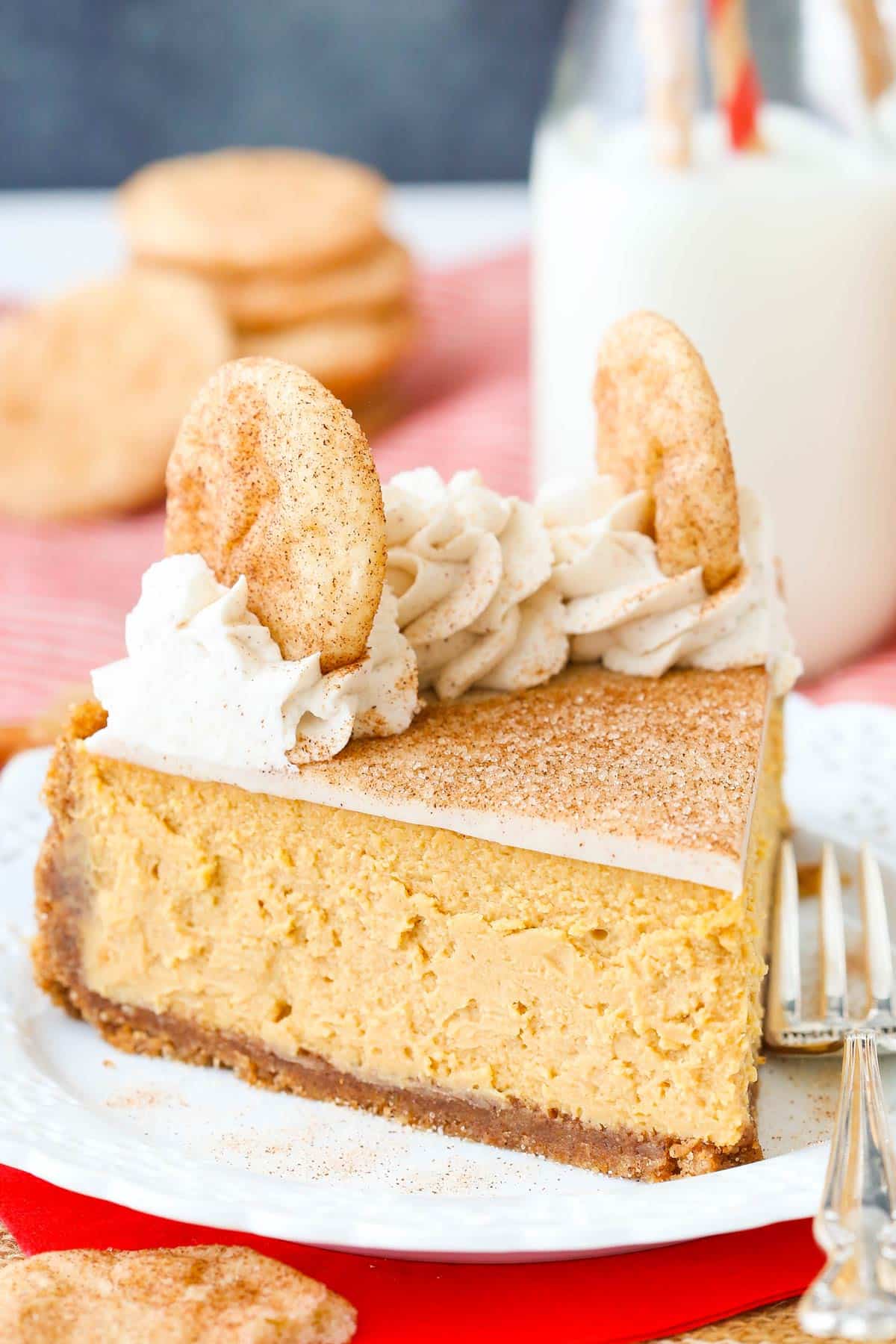 Side view of a slice of snickerdoodle dulce de leche cheesecake on a small white plate.