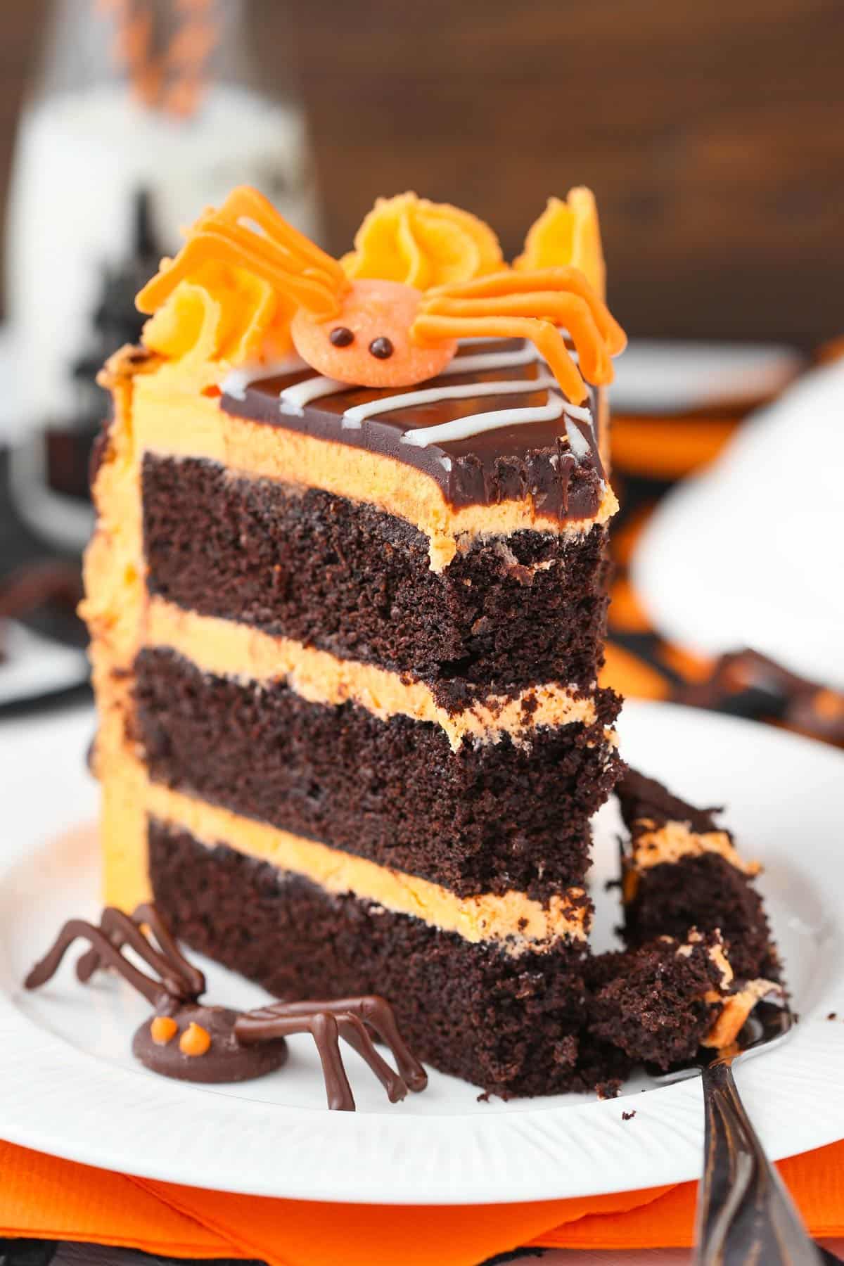 A slice of spiderweb chocolate cake with a bite removed on a fork.