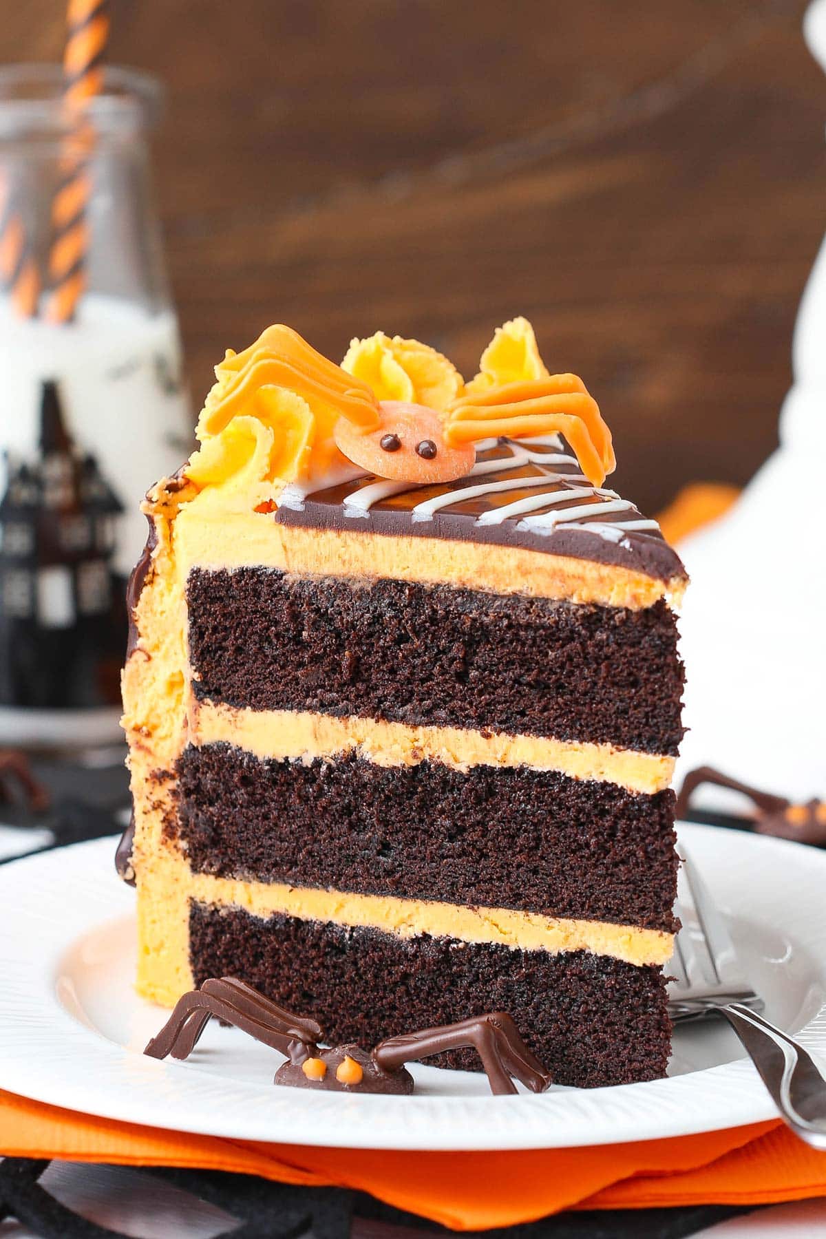Close up of a slice of spiderweb chocolate cake on a white plate.