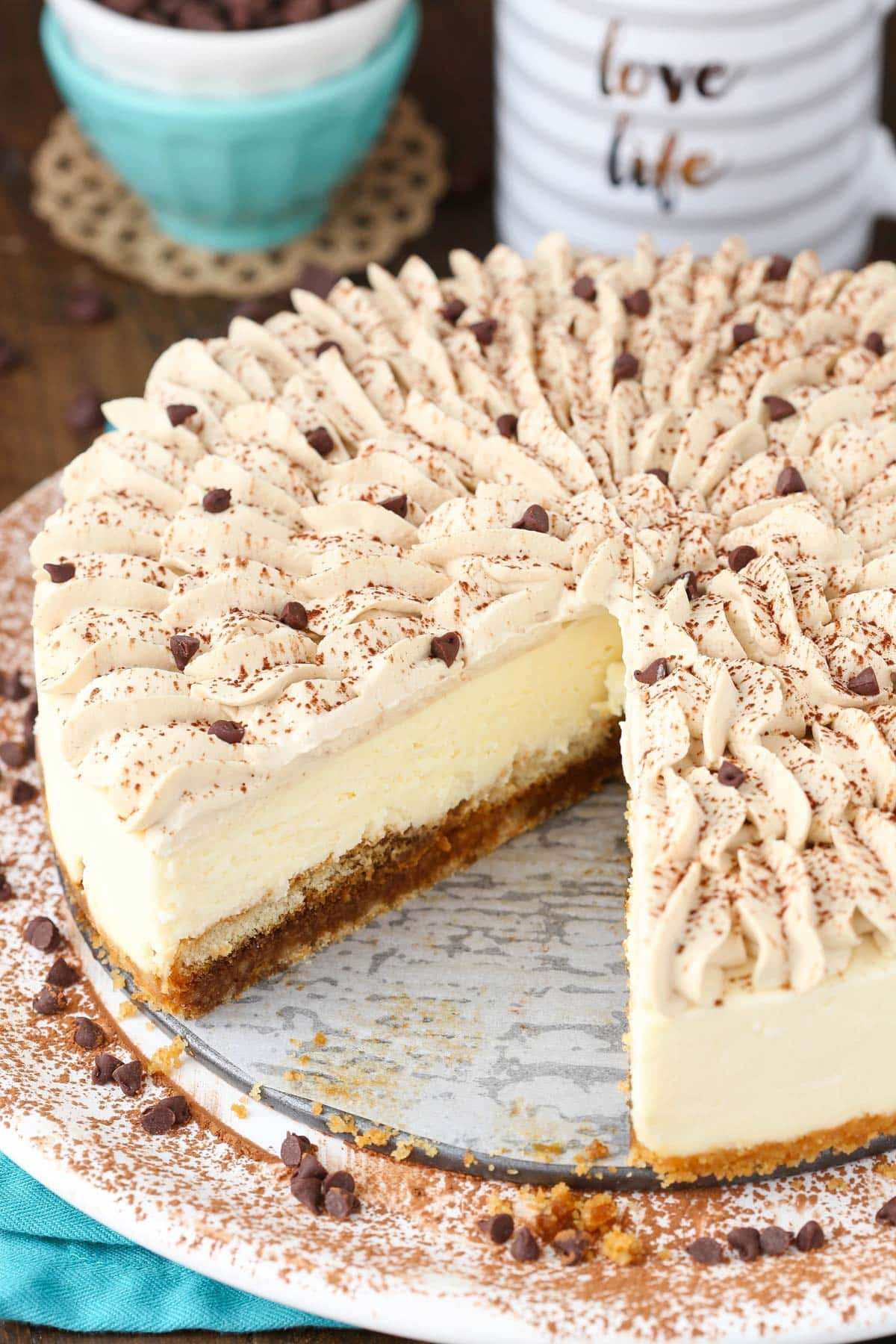 A tiramisu cheesecake with a slice removed to show inside layers.