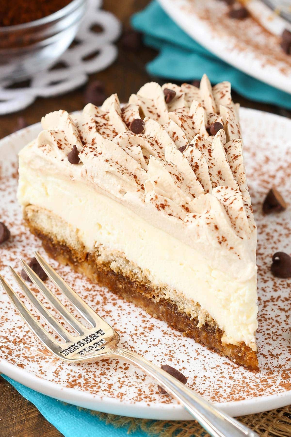 Close up of a slice of tiramisu cheesecake on a white plate.
