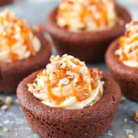 Close up of a turtle chocolate cookie cup on a silver tray.