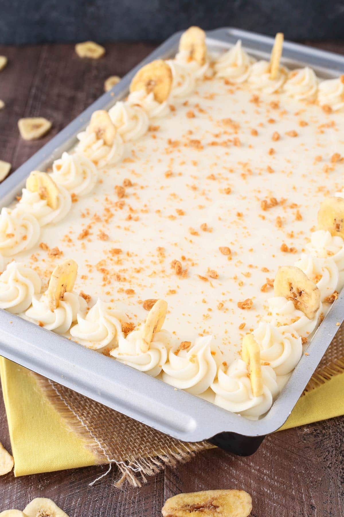 A frosted banana cake with cream cheese frosting in a baking pan.