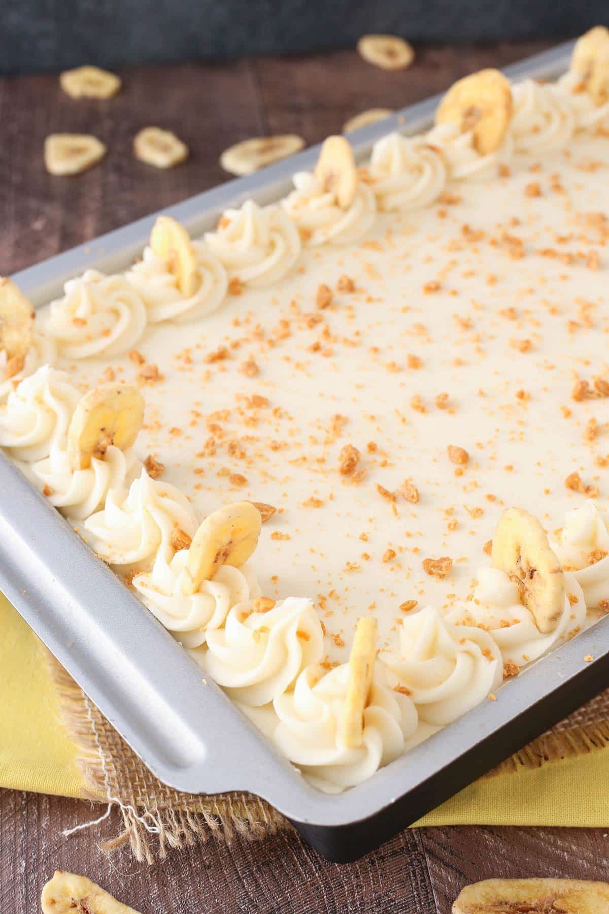 A frosted banana cake with cream cheese frosting in a baking pan.