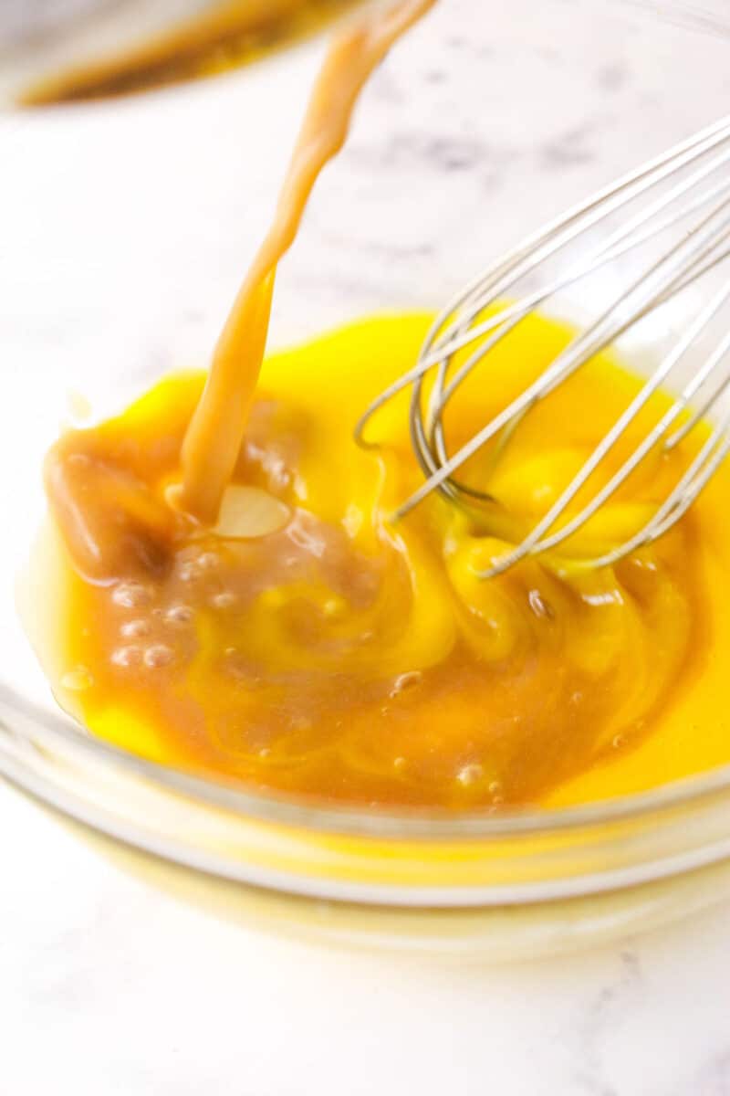 Tempering egg yolks with hot butterscotch mixture.