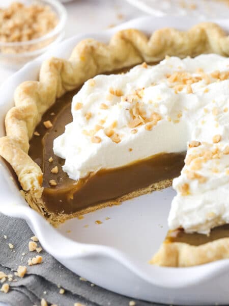 Butterscotch pie with a slice taken from it.