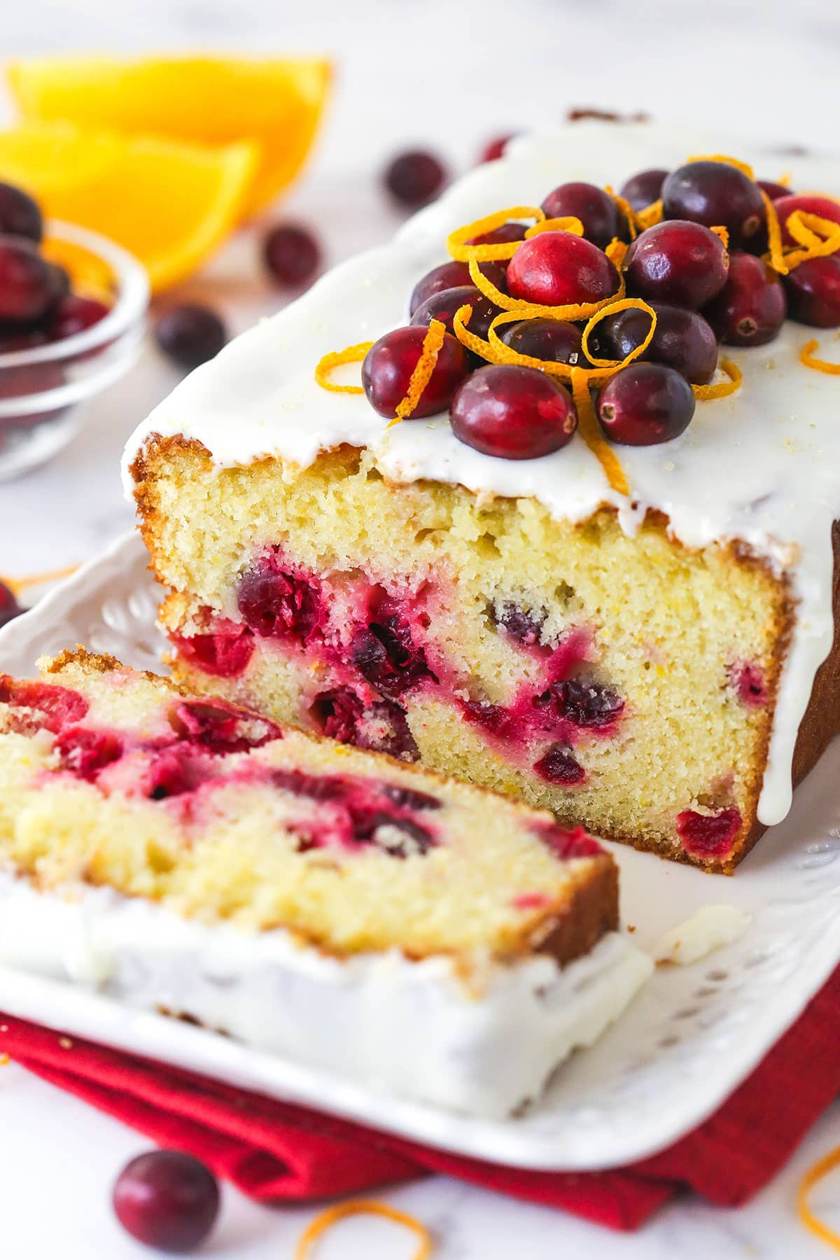 An orange cranberry loaf with a slice cut from it.