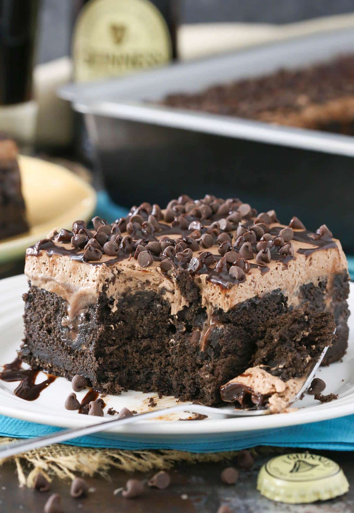 A slice of Guinness chocolate poke cake with a bite removed on a fork.