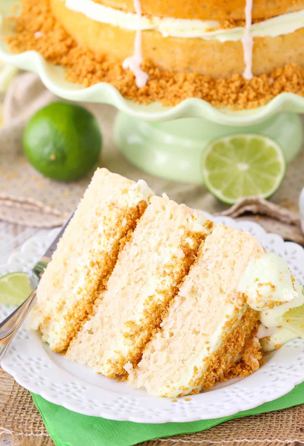 Close up of a slice of key lime pie layer cake on a white plate.