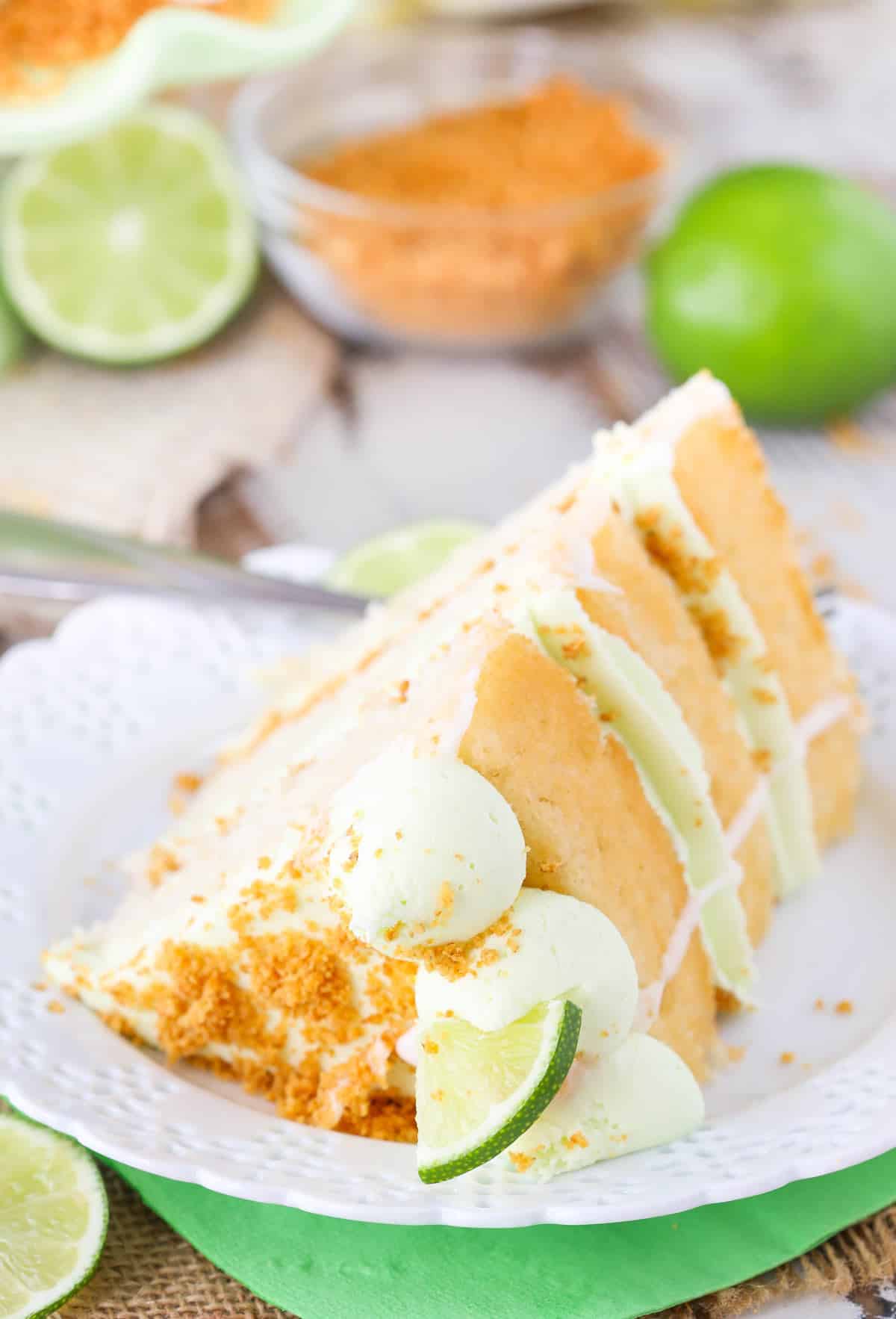 A slice of key lime pie layer cake on a white plate.