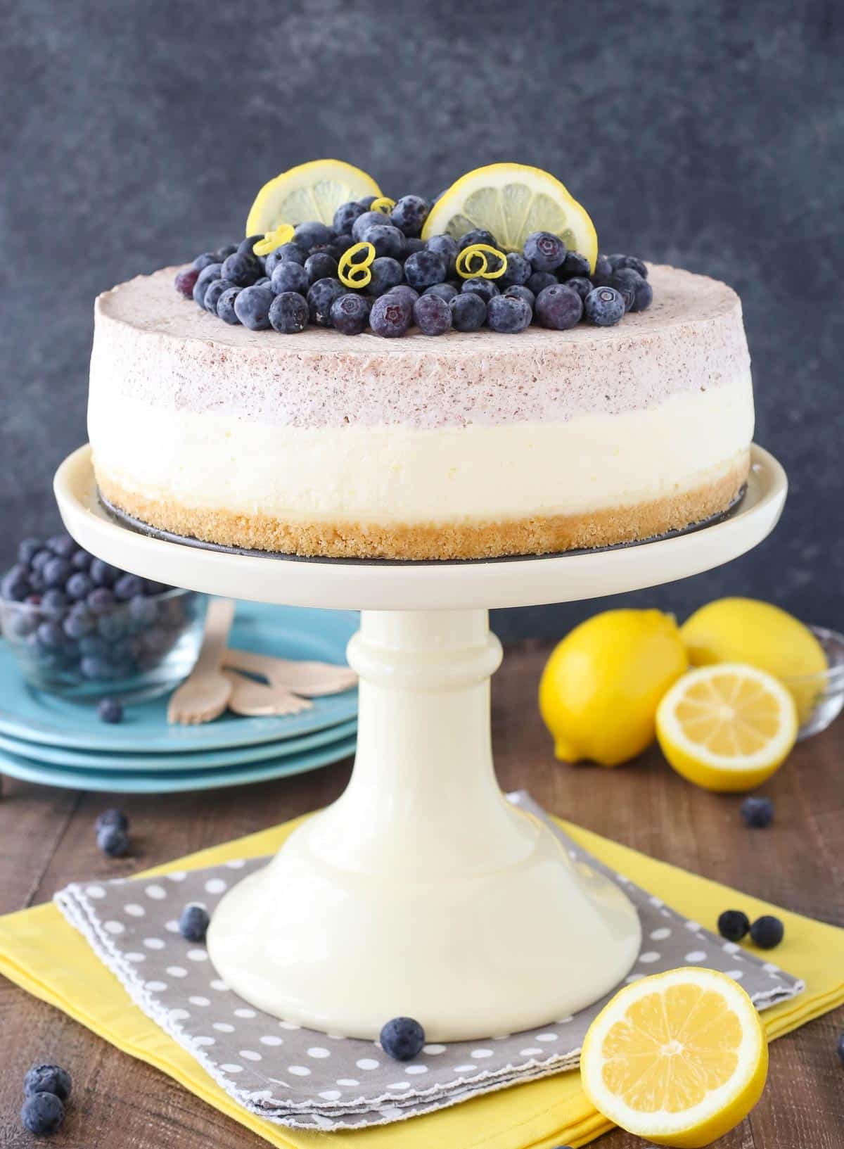 A lemon blueberry shortbread mousse cake on a white cake stand.