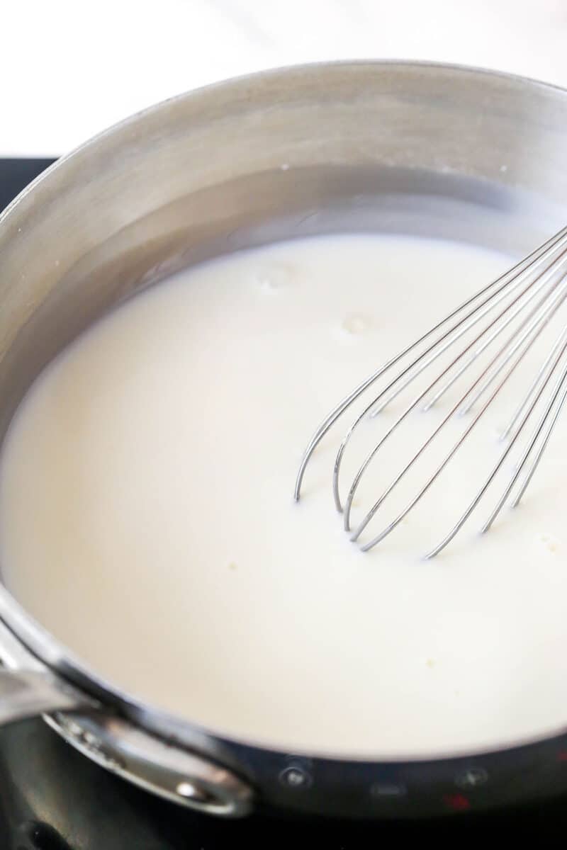 Whisking a simmering mixture of sugar, cornstarch, and milk.
