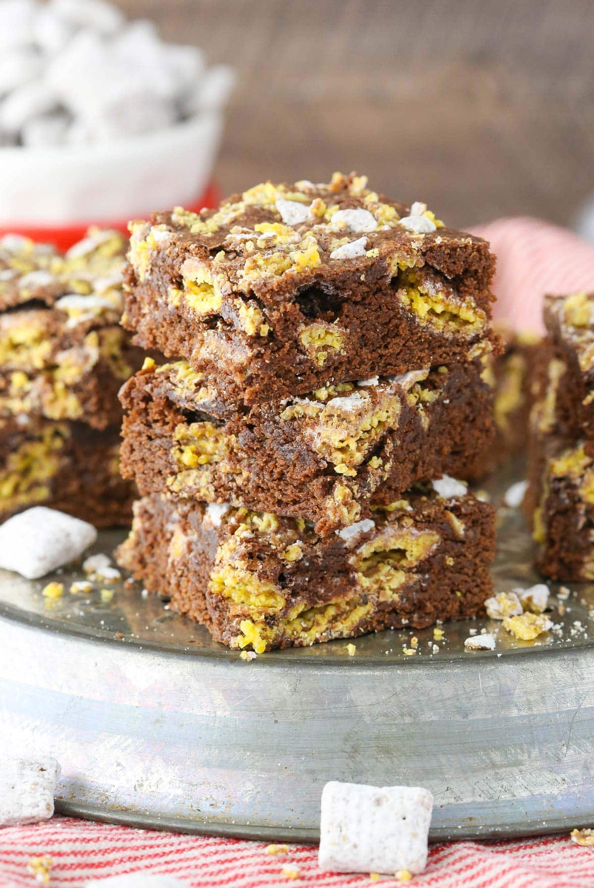 Close up of a stack of muddy buddy brownies on a silver tray.
