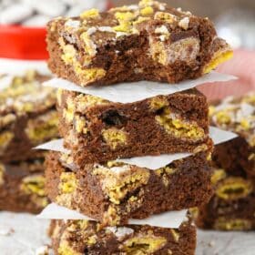 Four muddy buddy brownies stacked one on top of the other.