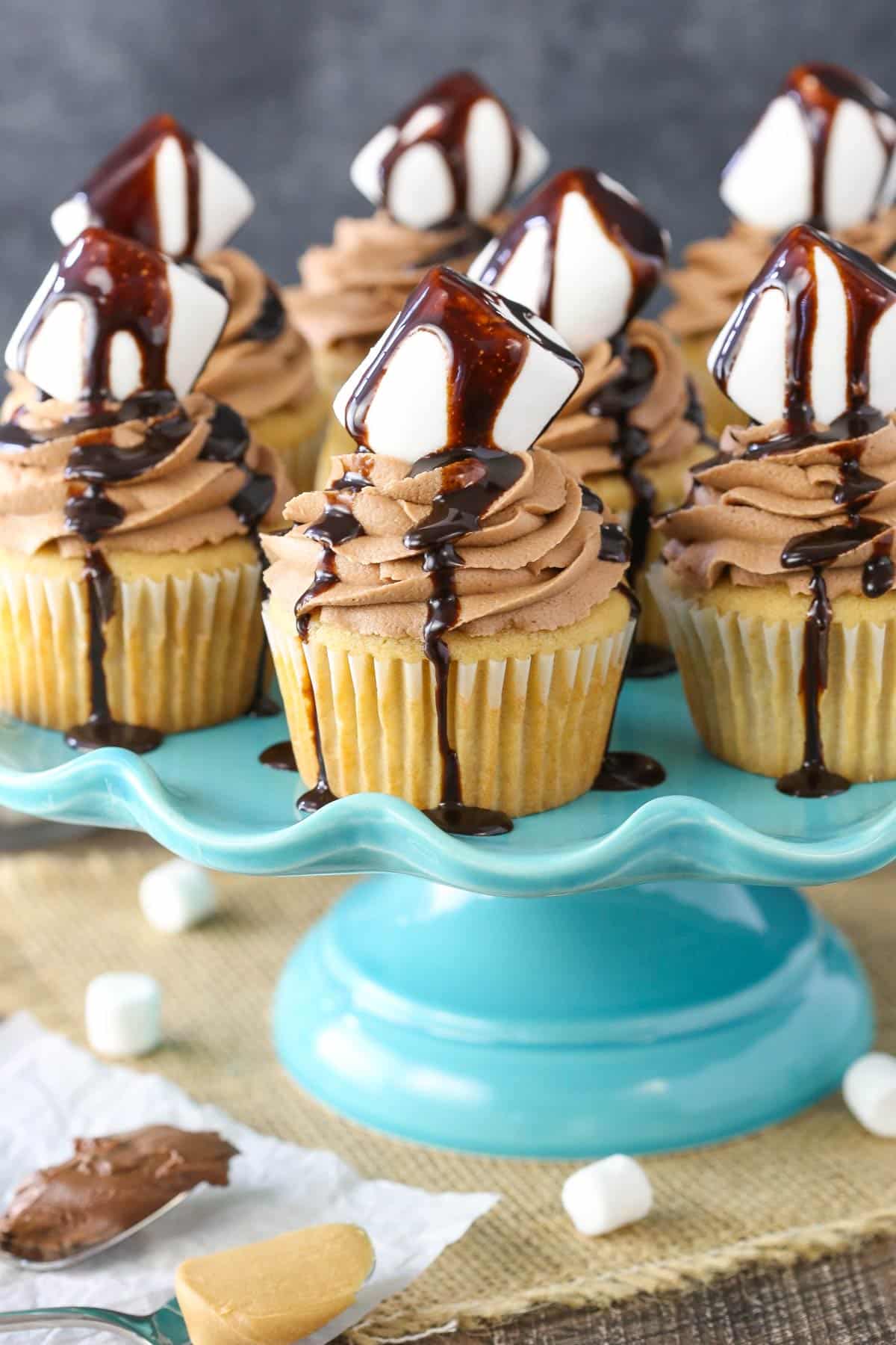 A blue cake stand topped with Nutella fluffernutter cupcakes.