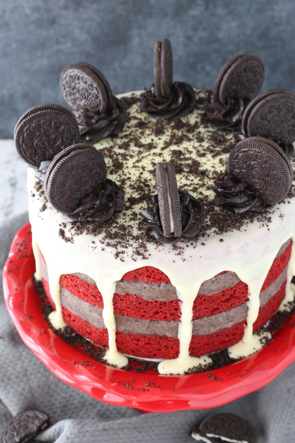 Top view of an Oreo cookie dough red velvet blondie layer cake on a red cake stand.