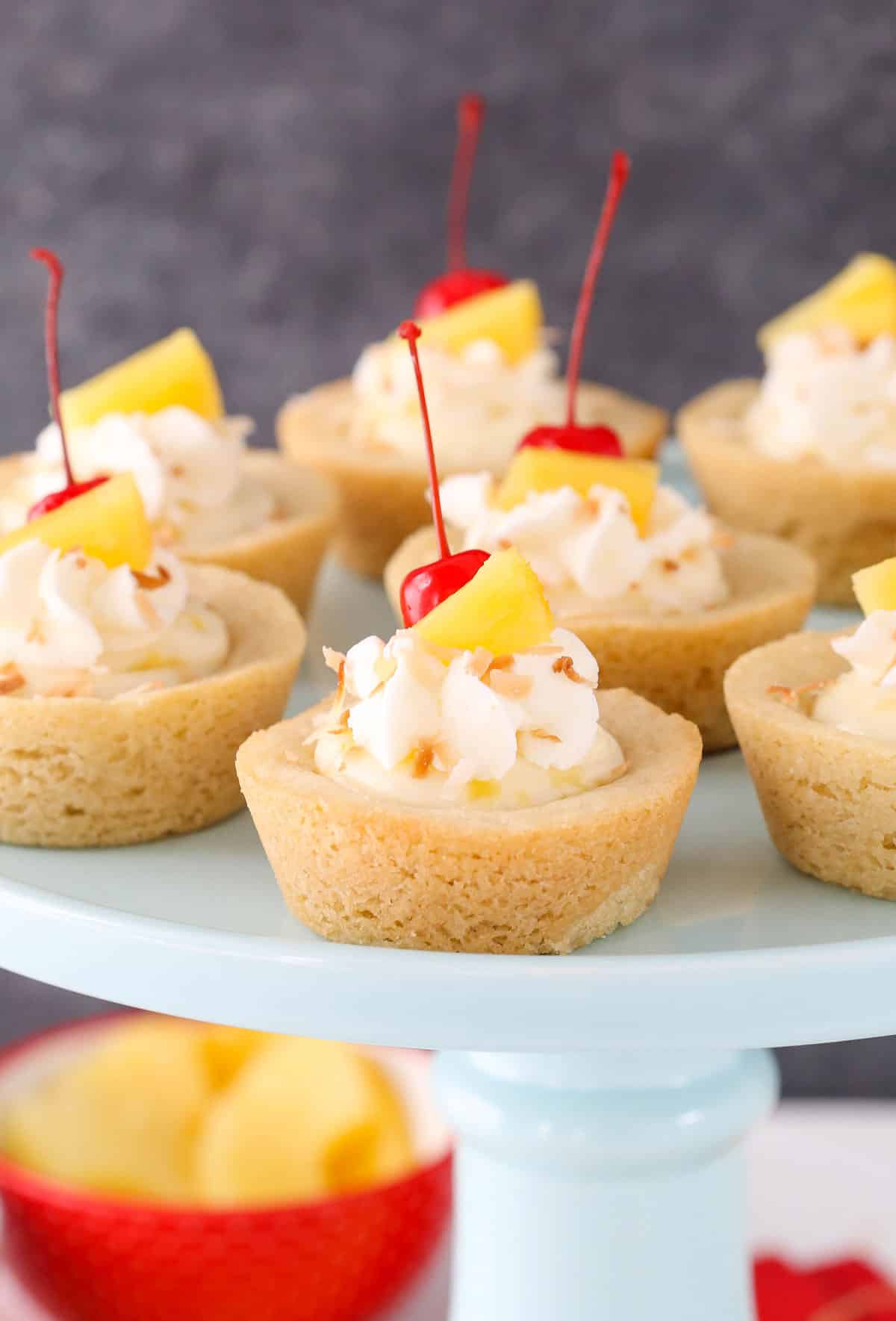 Close up of pina colada cookie cups on a light blue cake stand.