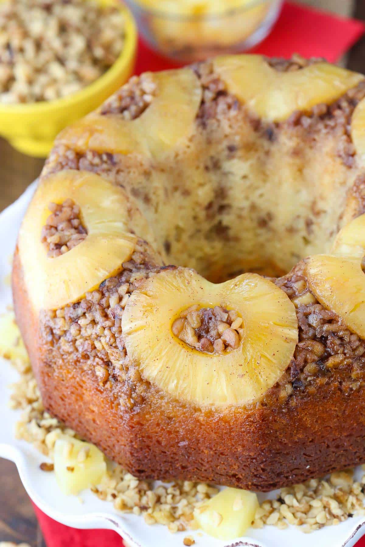 Close up of the top of a pineapple walnut upside down cake on a white cake plate.