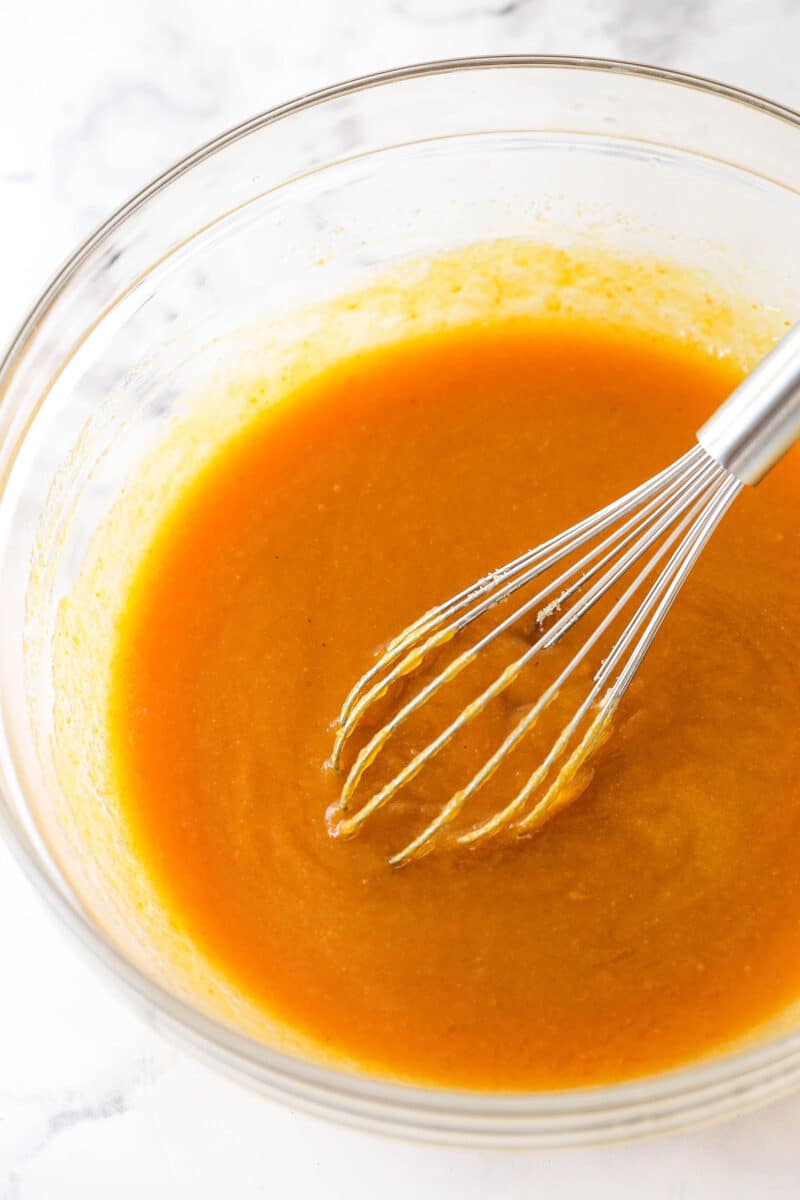 Whisking together butter, sugars, and vanilla, then whisk in the pumpkin puree.