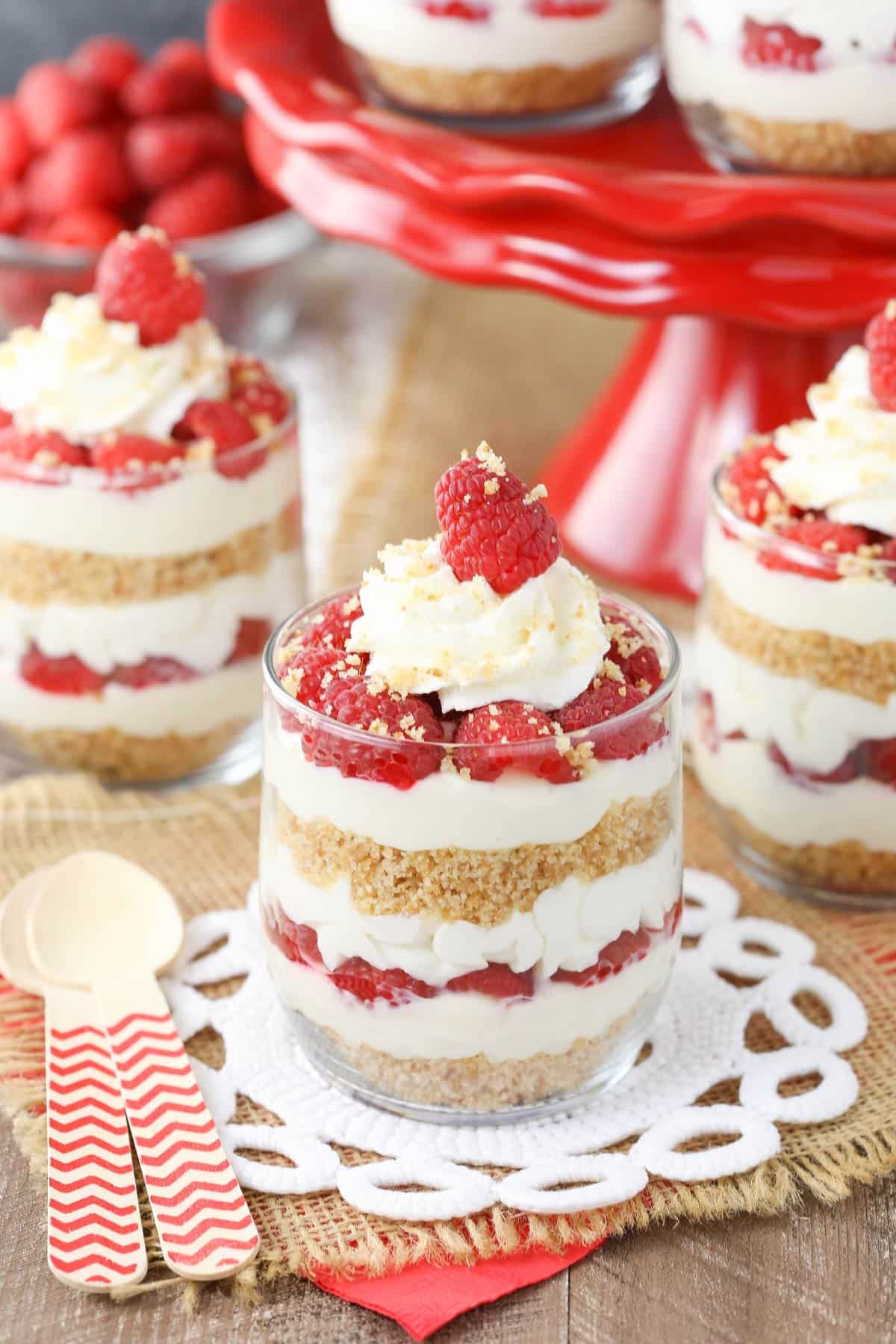Close up of a raspberry amaretto cheesecake trifle with more trifles in the background.