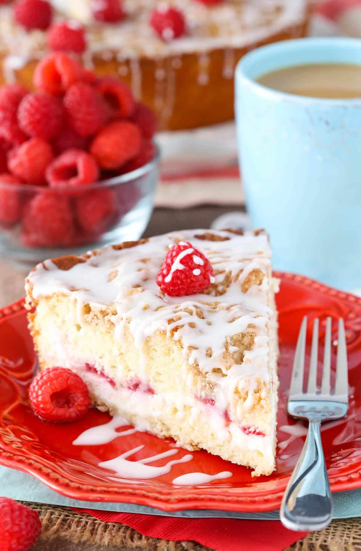 A slice of raspberry cream cheese coffee cake on a small red plate.