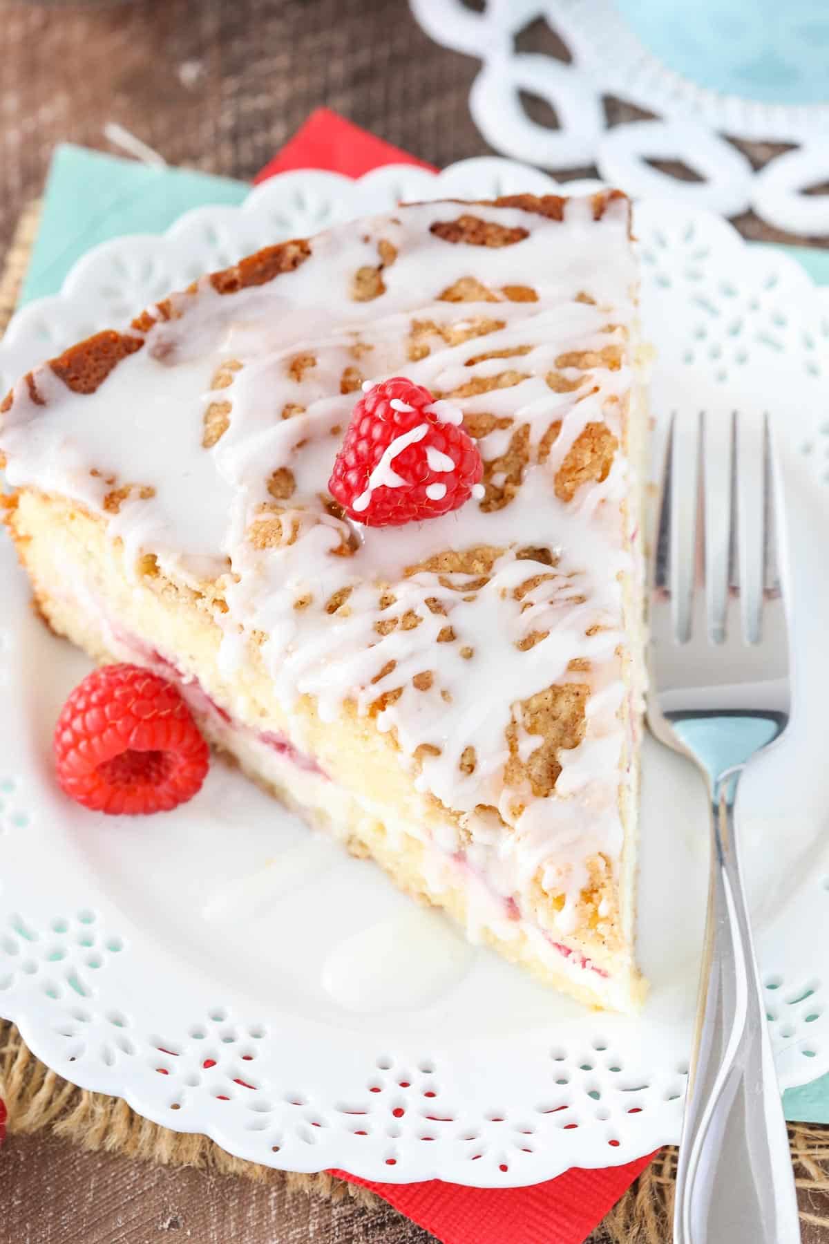 Top view of a slice of raspberry cream cheese coffee cake on a small white plate.