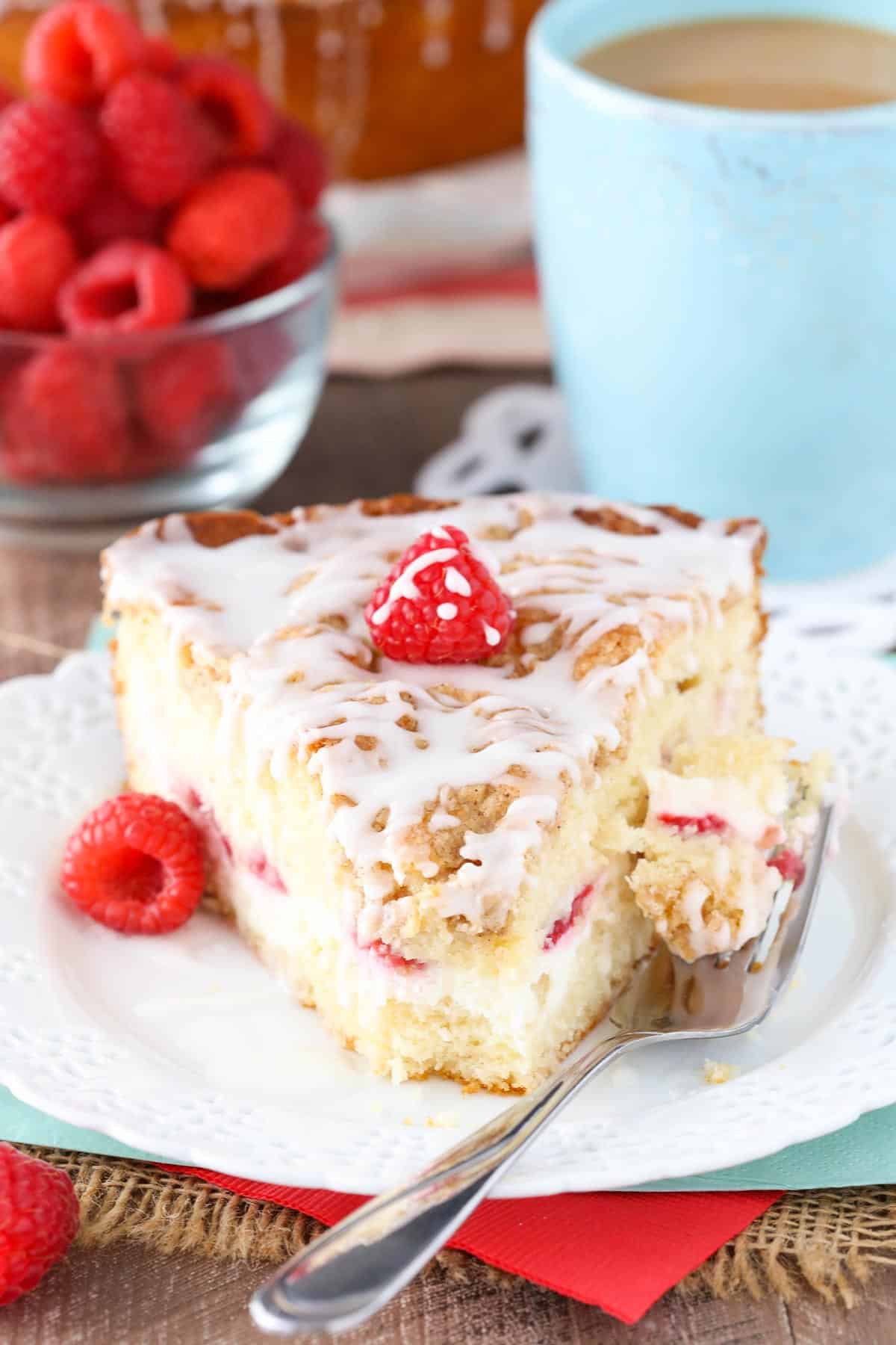 A slice of raspberry cream cheese coffee cake with a bite removed on a fork.
