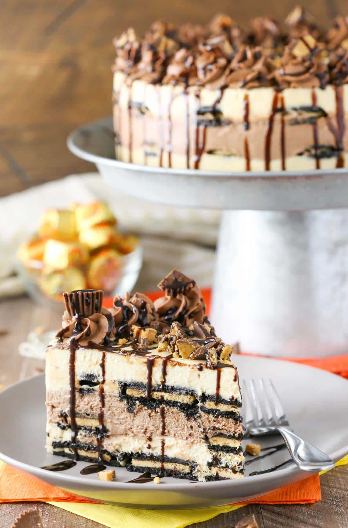 A slice of Reese's peanut butter chocolate icebox cake with the rest of the cake in the background.
