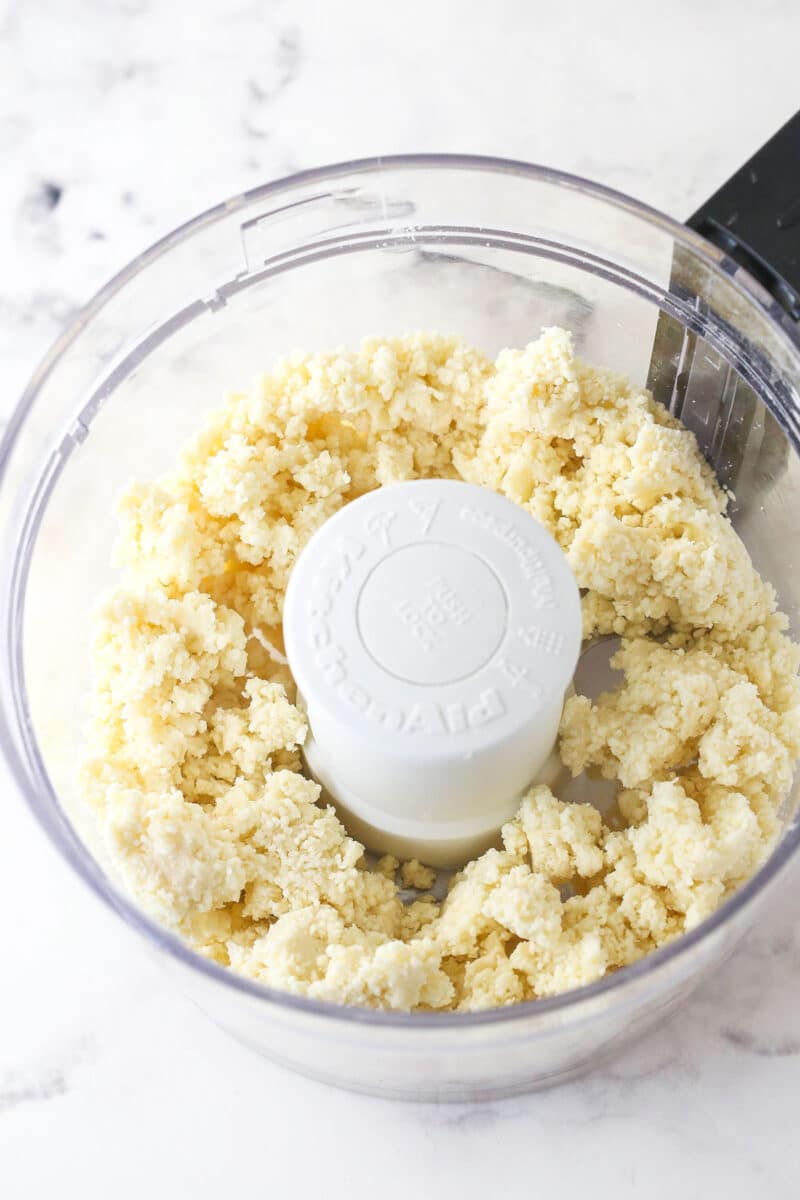 Pulsing together butter, flour, and salt in a food processor.
