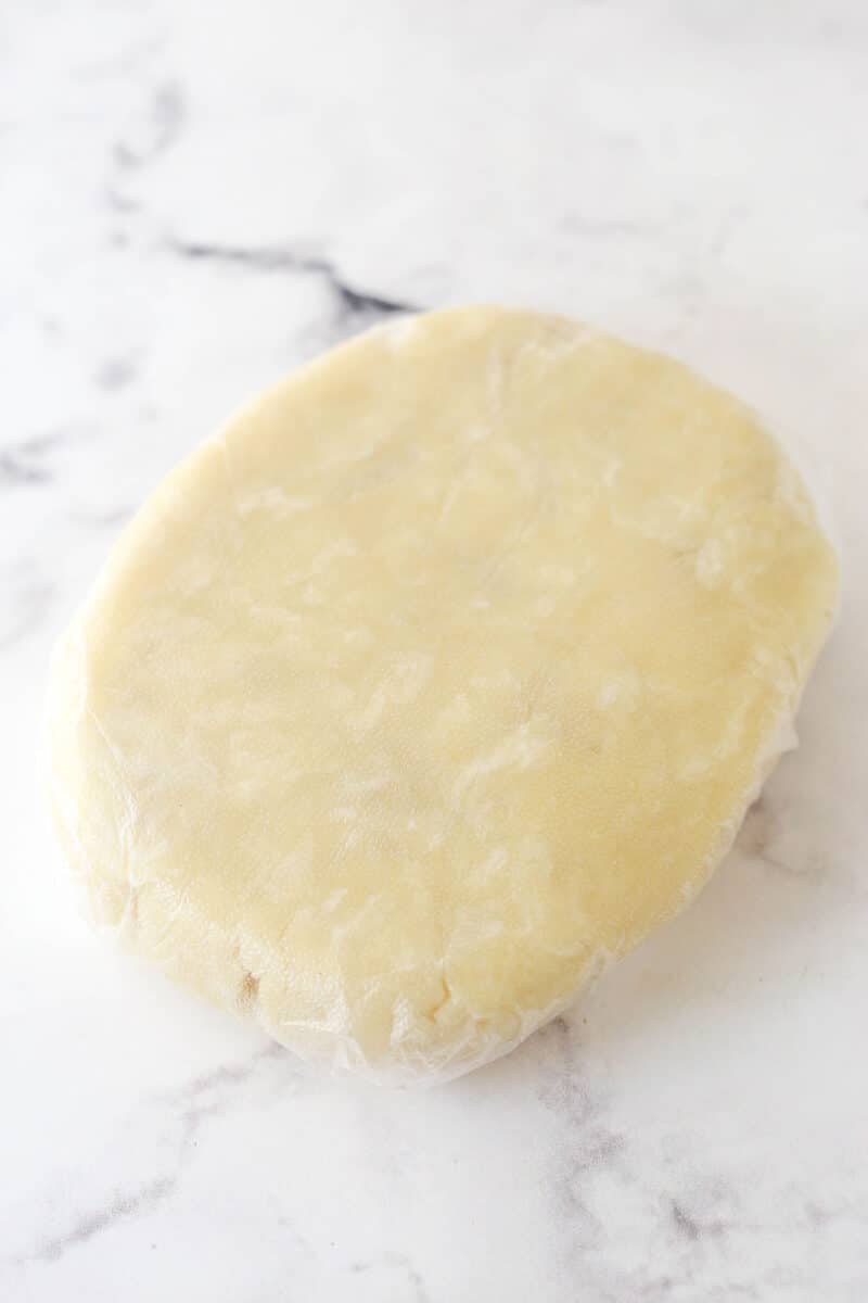 Pie dough wrapped in plastic.