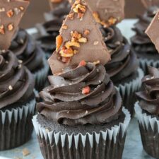 Close up of smokey bourbon chocolate cupcakes with bacon bark on a silver tray.