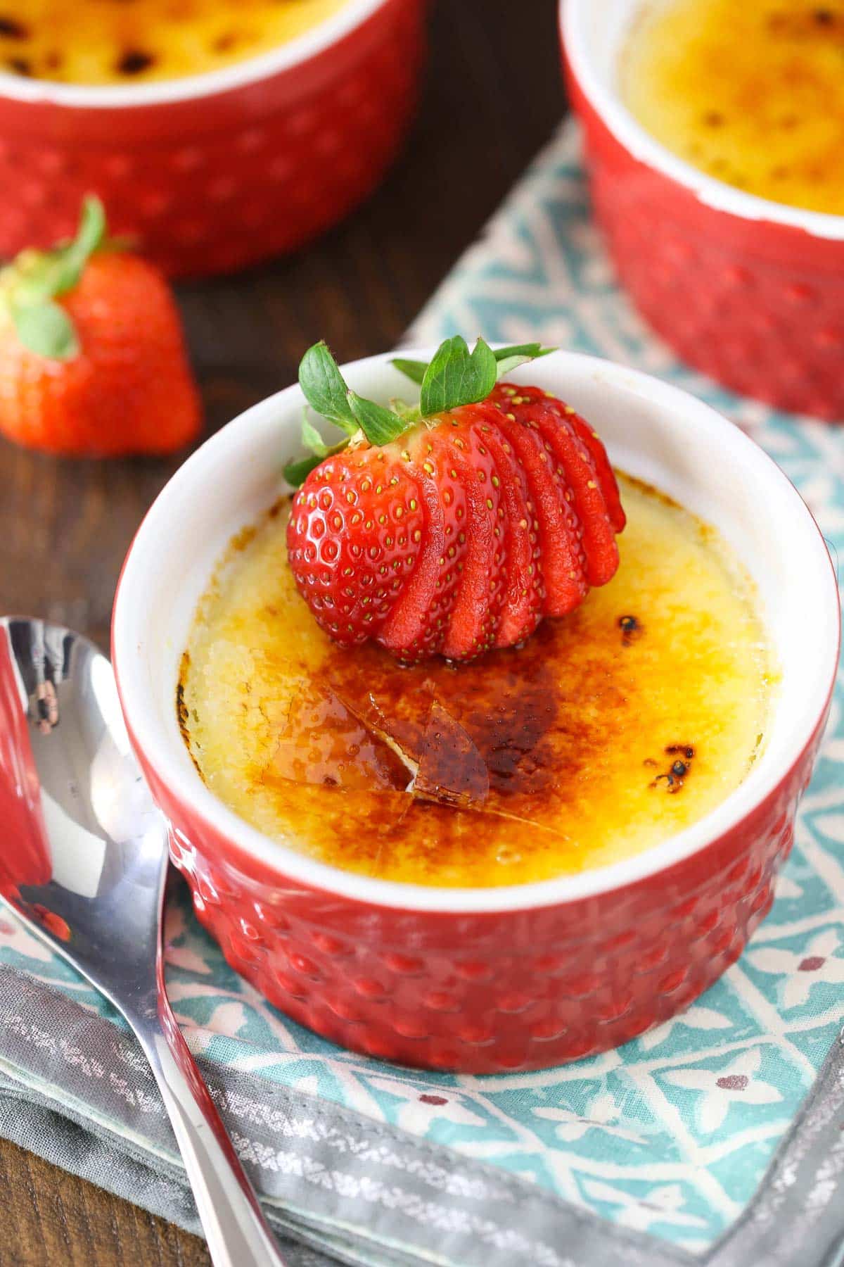Top view of a red ramekin filled with strawberries brulee.