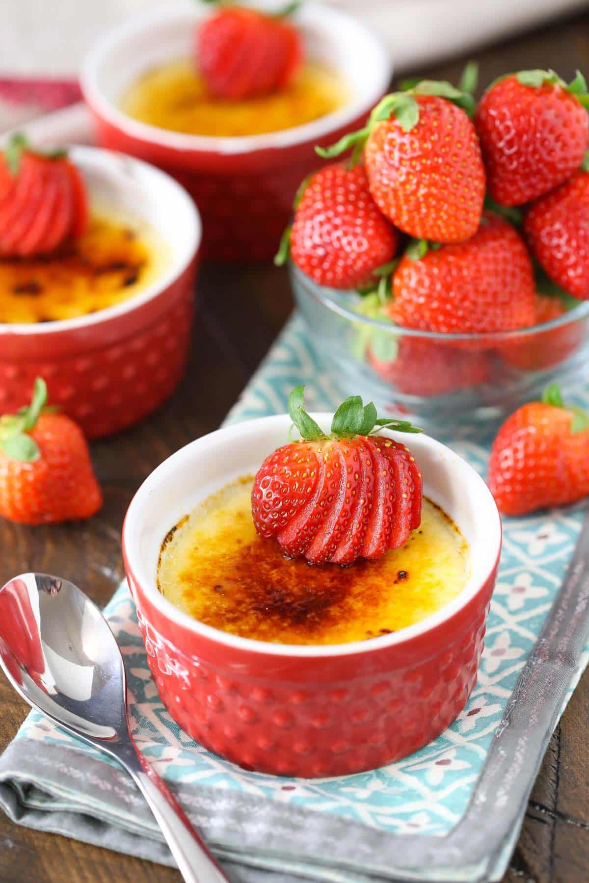 Close up of a red ramekin filled with strawberries brulee.