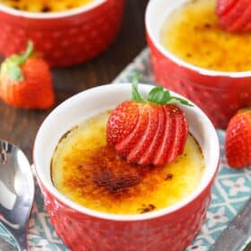 A red ramekin with strawberries brulee.