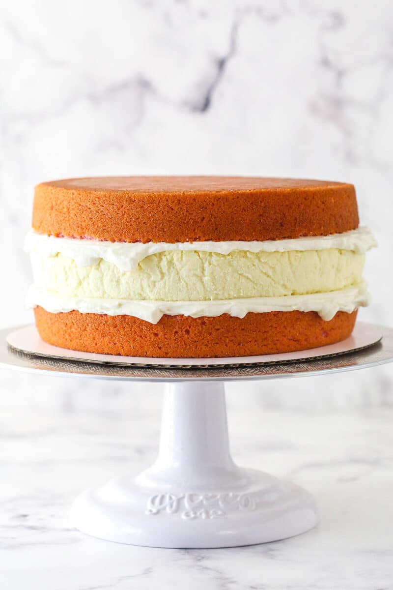 A layer of cheesecake sandwiched between 2 strawberry cake layers.