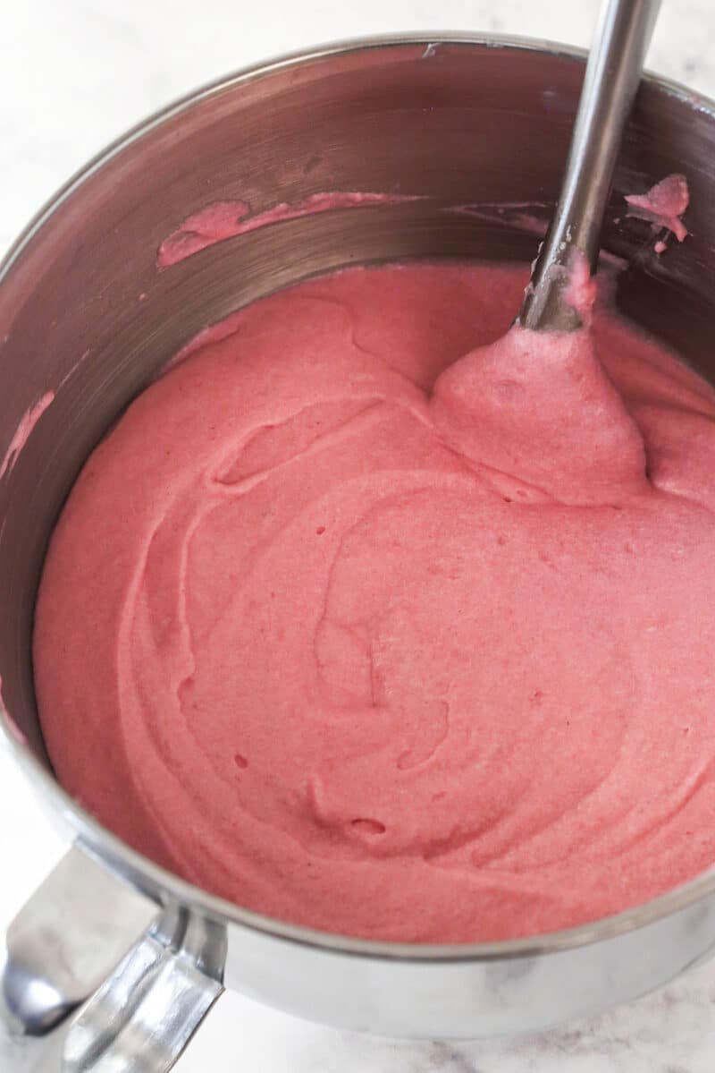 Folding whipped egg whites into strawberry cake batter.